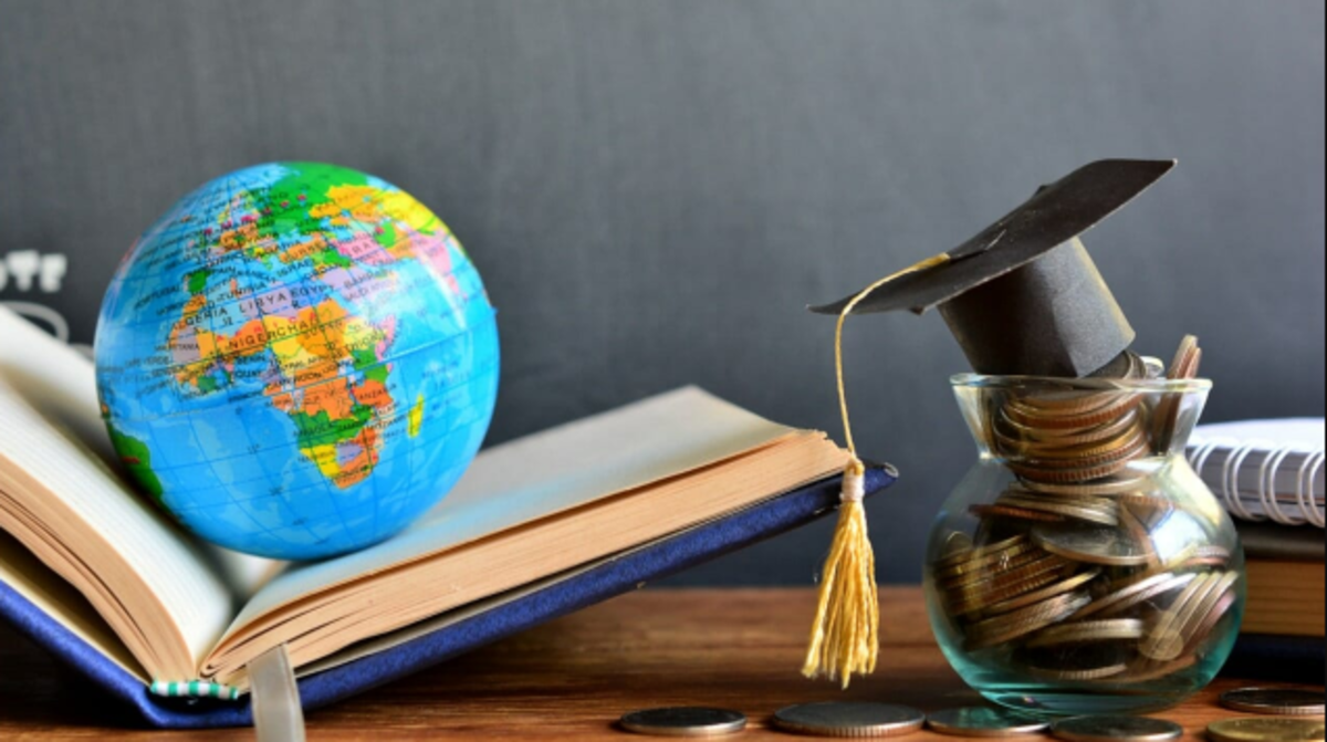 A globe with a graduation cap and money, representing global education and scholarship opportunities.